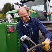 Landwirtschaftlichen Rentenbank Ein Bauer steht vor seinem Traktor